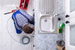 a plumber fixing kitchen drains